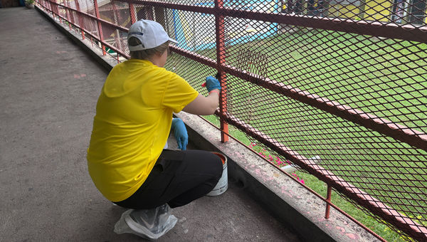 ALG Vacations' Suzanne Schreiber paints a balcony fence at Catherine Hall School.